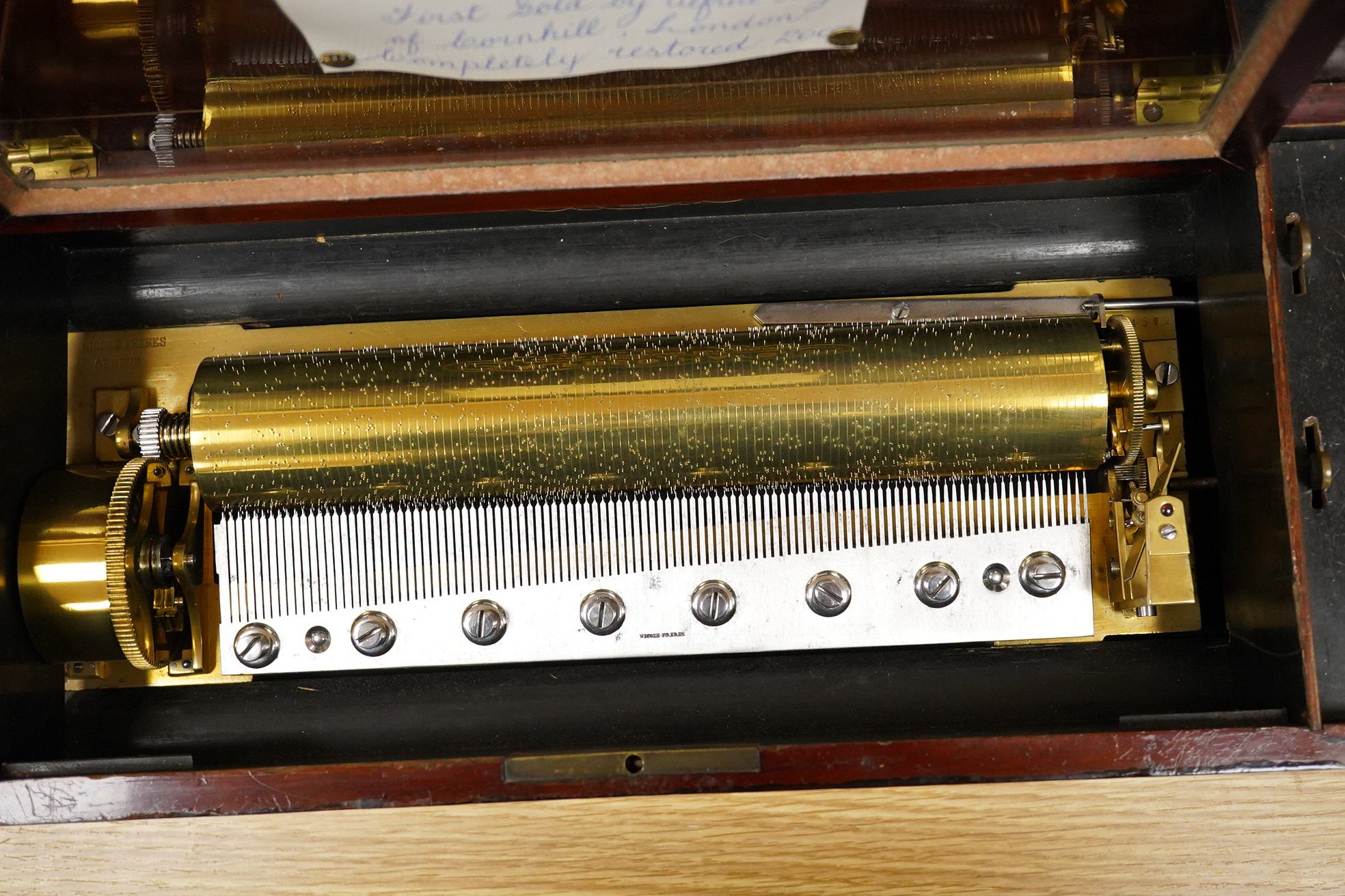 A late 19th century inlaid and ebonised rosewood Swiss cylinder music box by Nicole Freres, Geneve, and retailed by Alfred Hays, 4, Royal Exchange Buildings, complete with all teeth to the comb, cylinder 27.8cm long, the